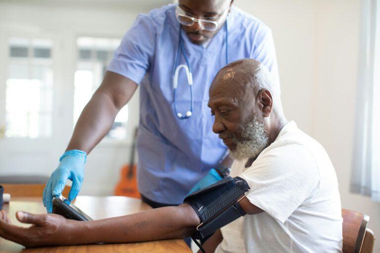 Médico aferindo pressão arterial de paciente homem durante check-up de saúde