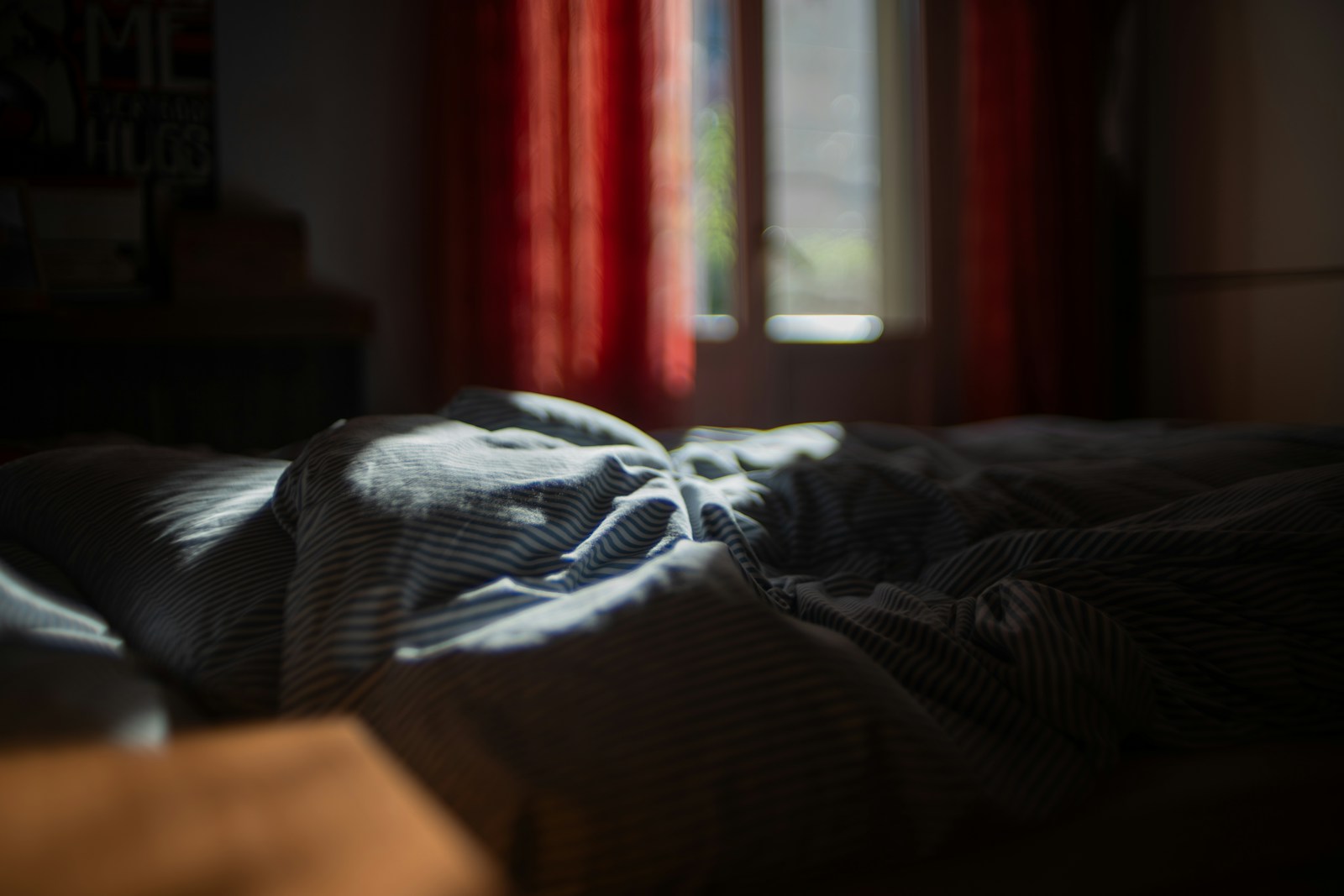 Quarto escuro com cama desfeita — sono profundo é onde a recuperação masculina realmente acontece